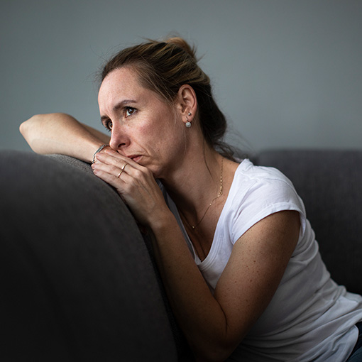 woman suffering from depression sitting on couch